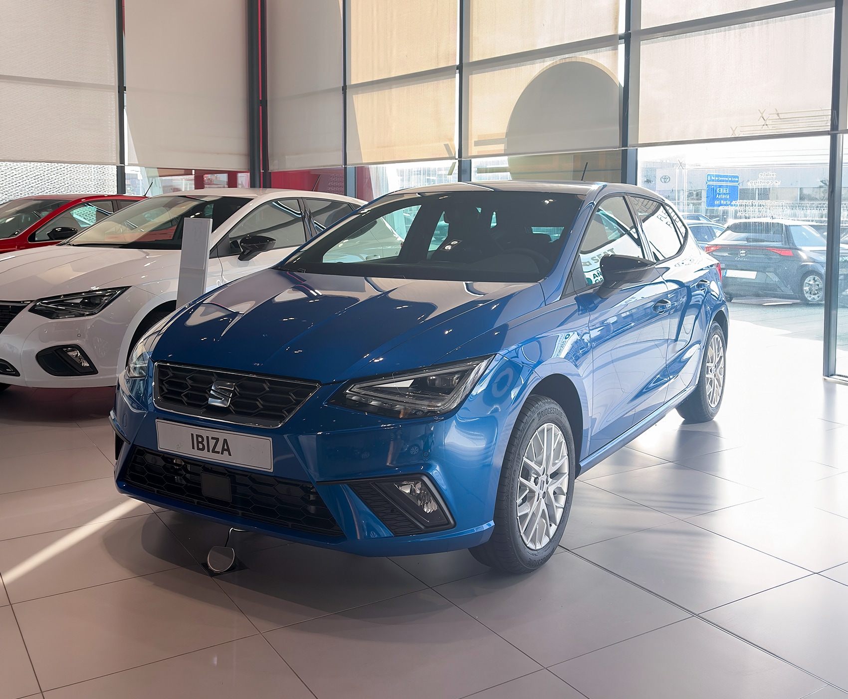Vista completa de un SEAT Ibiza 2026 de color rojo, aparcado al aire libre