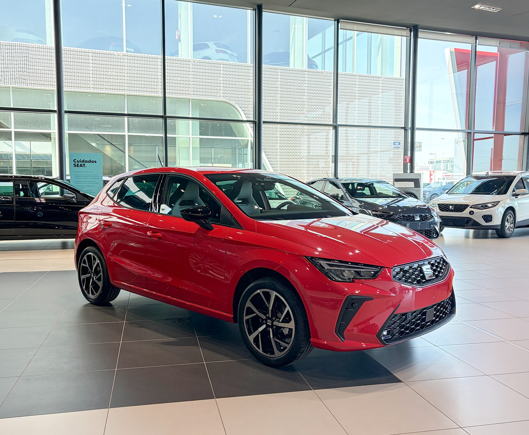 Vista completa de un SEAT Ibiza 2026 de color rojo, aparcado al aire libre