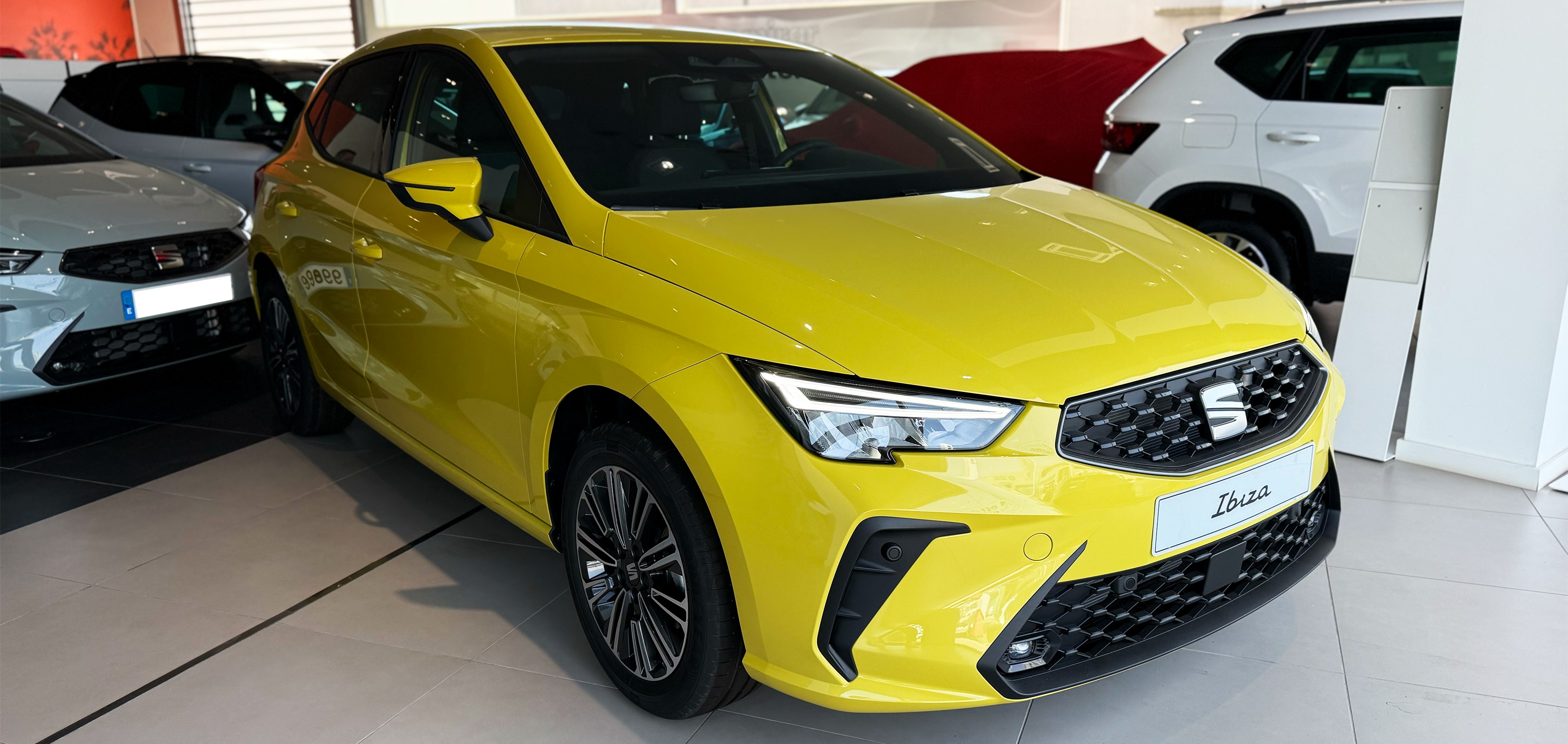 Vista completa de un SEAT Ibiza 2026 de color rojo, aparcado al aire libre