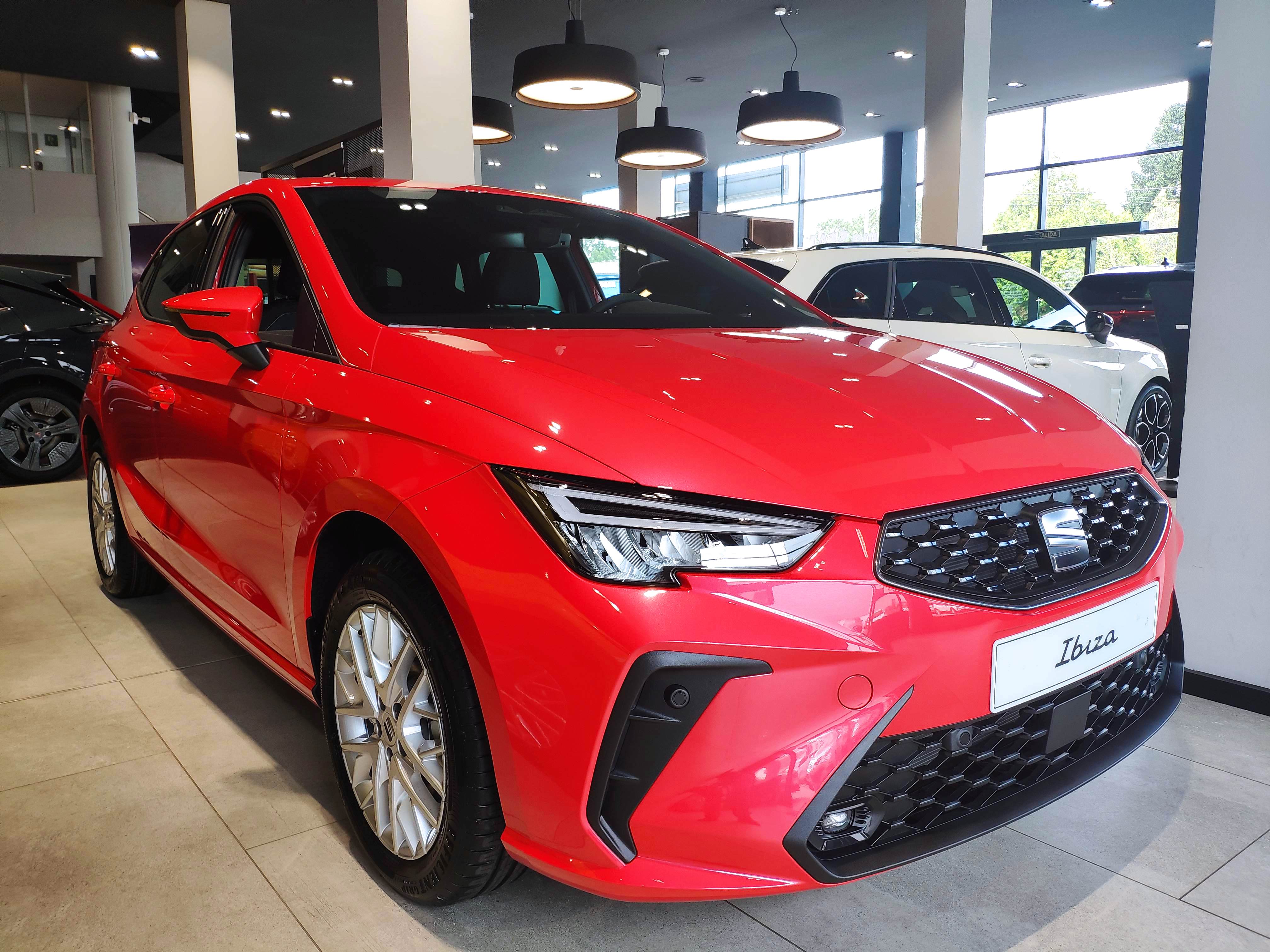 Vista completa de un SEAT Ibiza 2026 de color rojo, aparcado al aire libre
